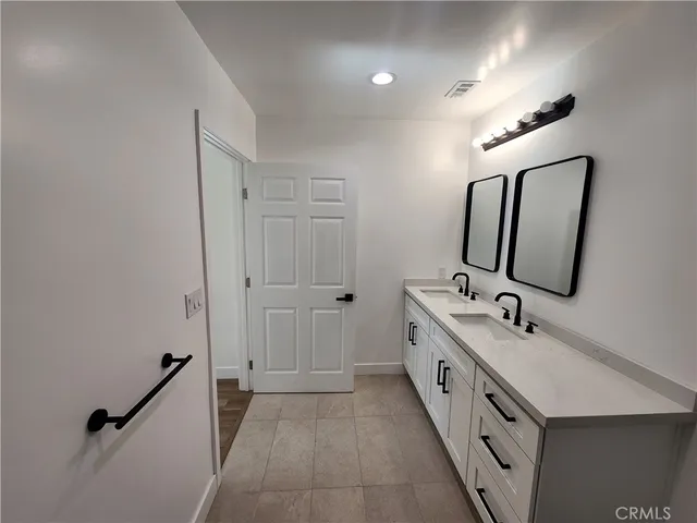 a bathroom with 2 sink tub and mirror