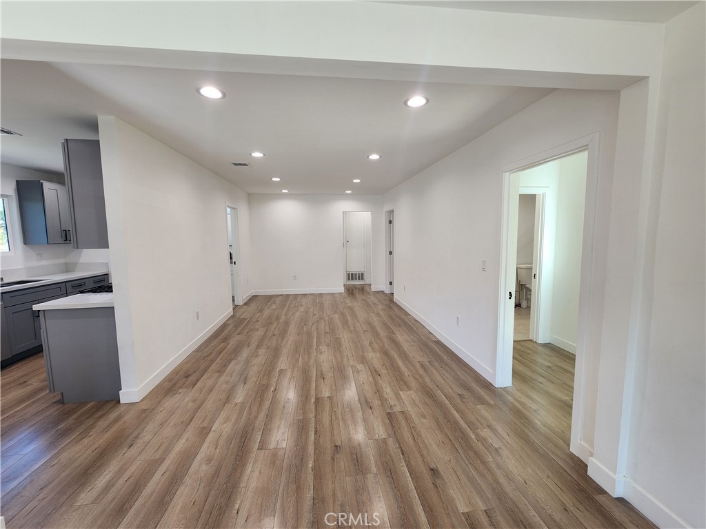 7665 Machrea Street Tujunga, CA 91042 - Photo 22 of 43 a view of a big room with wooden floor and a kitchen