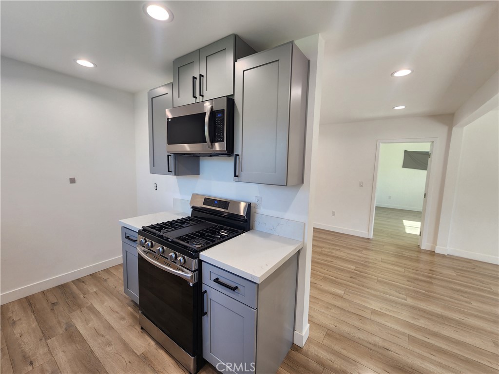 7665 Machrea Street Tujunga, CA 91042 - Photo 25 of 43 a kitchen with stainless steel appliances granite countertop a stove a refrigerator and a microwave