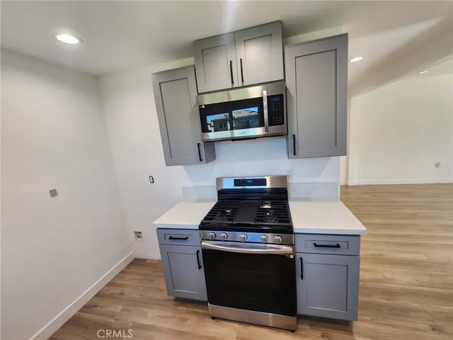 a kitchen with stainless steel appliances granite countertop a stove a microwave and a sink