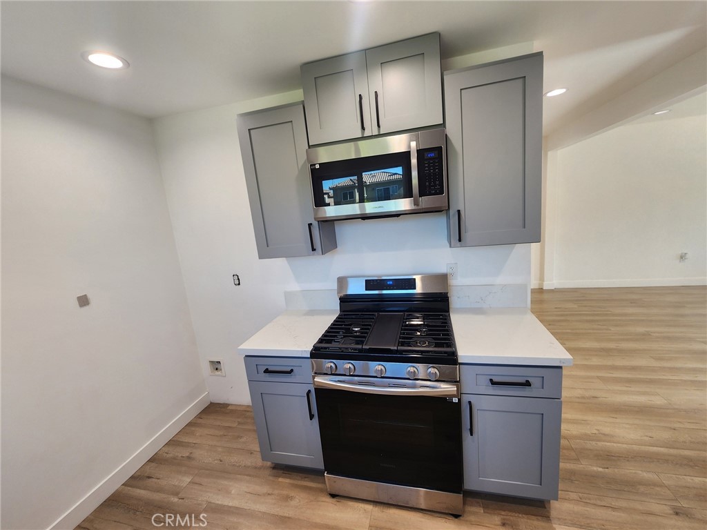 7665 Machrea Street Tujunga, CA 91042 - Photo 26 of 43 a kitchen with stainless steel appliances granite countertop a stove a microwave and a sink