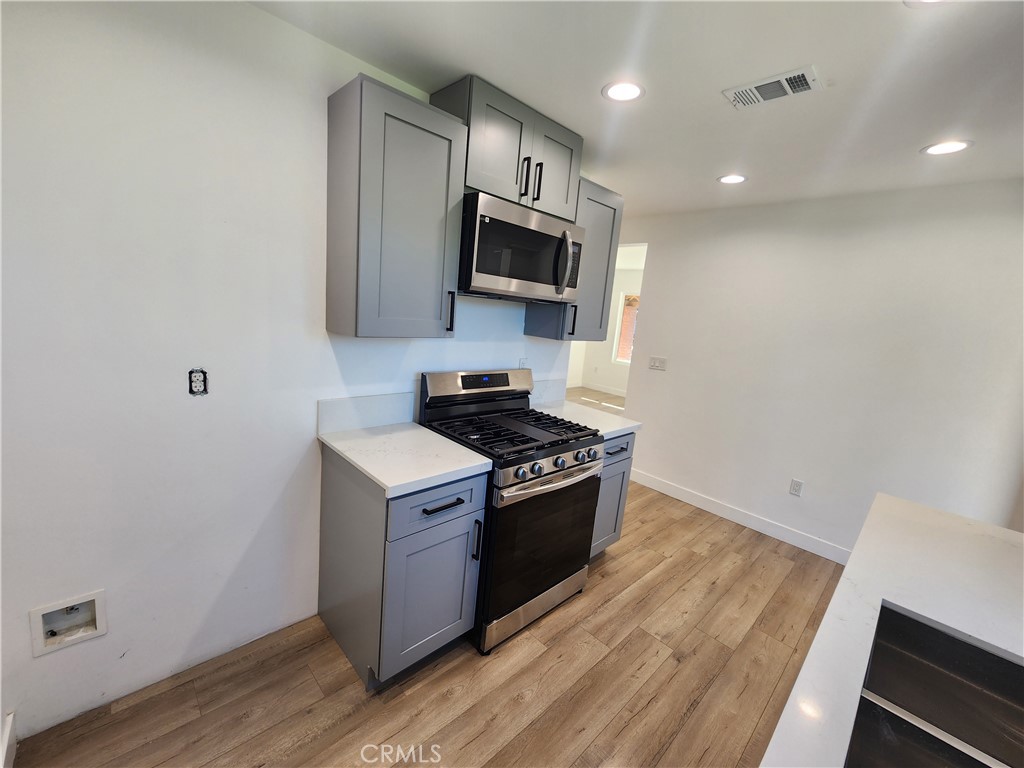 7665 Machrea Street Tujunga, CA 91042 - Photo 28 of 43 a kitchen with wooden floor and steel stainless steel appliances