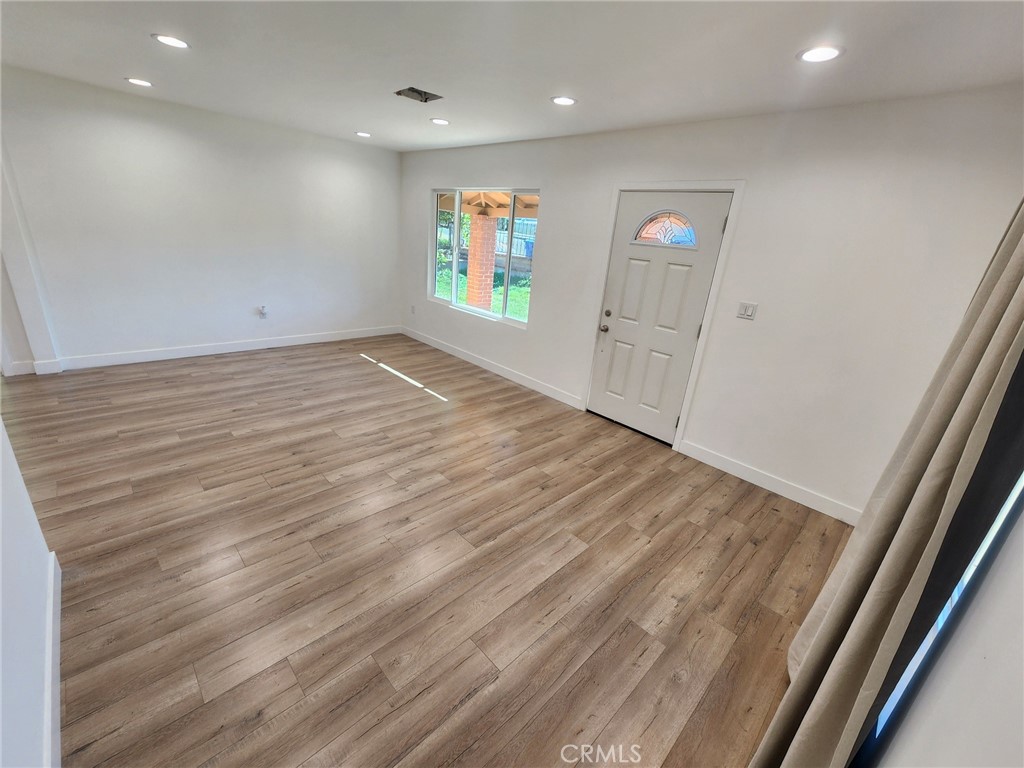 7665 Machrea Street Tujunga, CA 91042 - Photo 34 of 43 an empty room with wooden floor and windows