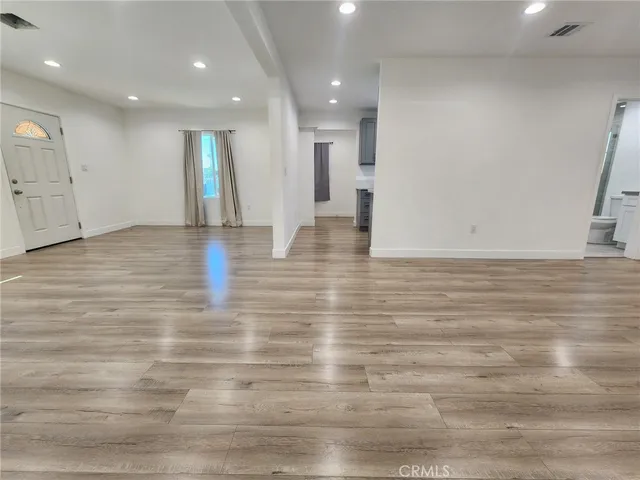 a view of an empty room with wooden floor