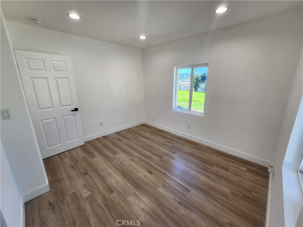 7665 Machrea Street Tujunga, CA 91042 - Photo 9 of 43 wooden floor in an empty room with a window