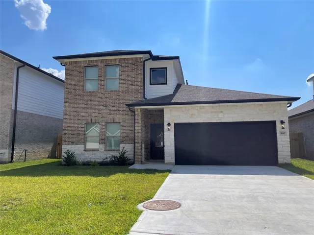 a front view of a house with a garden and yard