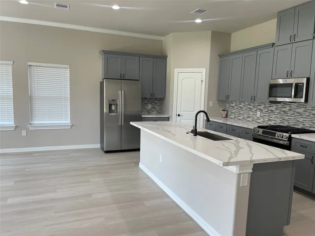a kitchen with stainless steel appliances granite countertop a sink stove and refrigerator