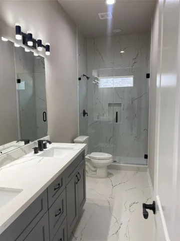 a bathroom with a sink a toilet and shower