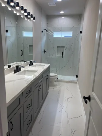 a bathroom with a double vanity sink mirror double and shower