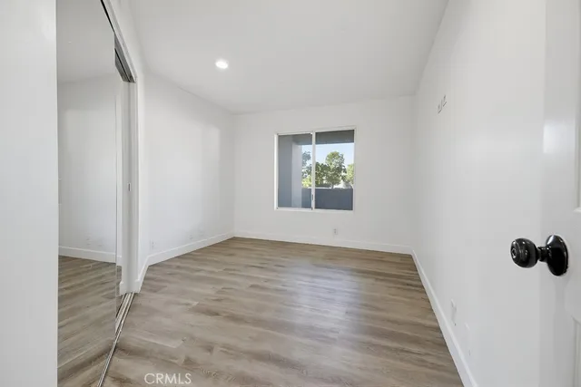 an empty room with closet and wooden floor