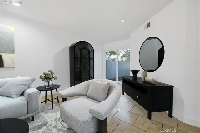 a living room with furniture and a mirror