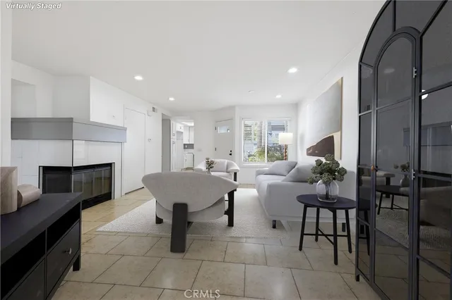 a living room with furniture a fireplace and a kitchen view