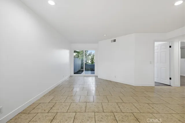 an empty room with windows and a fireplace