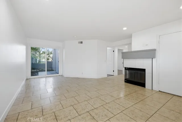 a view of an empty room with a fireplace and a window