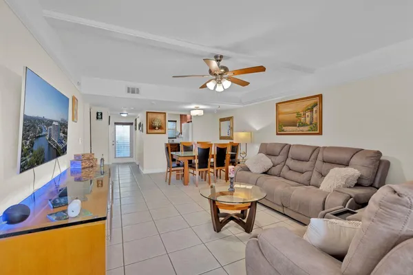 a living room with furniture kitchen view and a flat screen tv