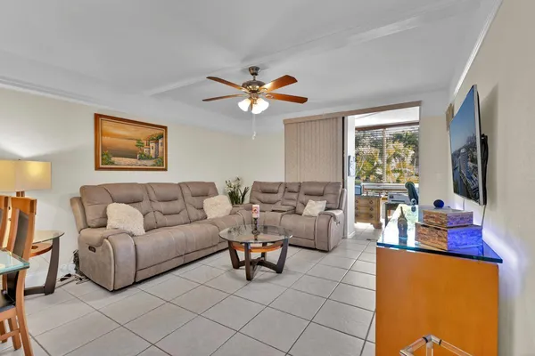 a living room with furniture a flat screen tv and a large window