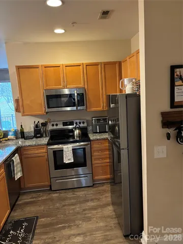 a kitchen with stainless steel appliances granite countertop a refrigerator stove and sink