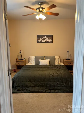a bedroom with a bed and a ceiling fan