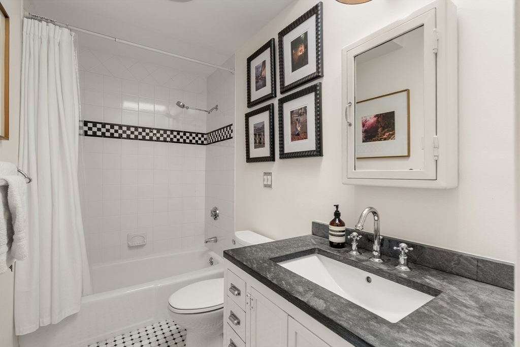 13 Upton Street, Unit 6 Boston, MA 02118 - Photo 7 of 27 a bathroom with a granite countertop sink a toilet a mirror a vanity a shower and bathtub