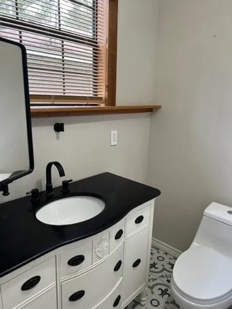 a bathroom with a sink a toilet and a window