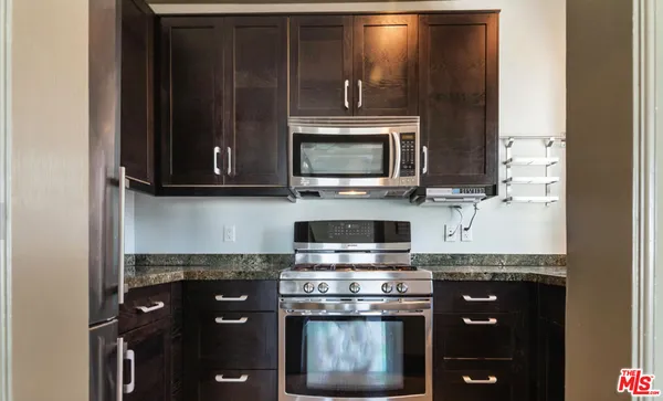 a kitchen with stainless steel appliances granite countertop a stove and a microwave