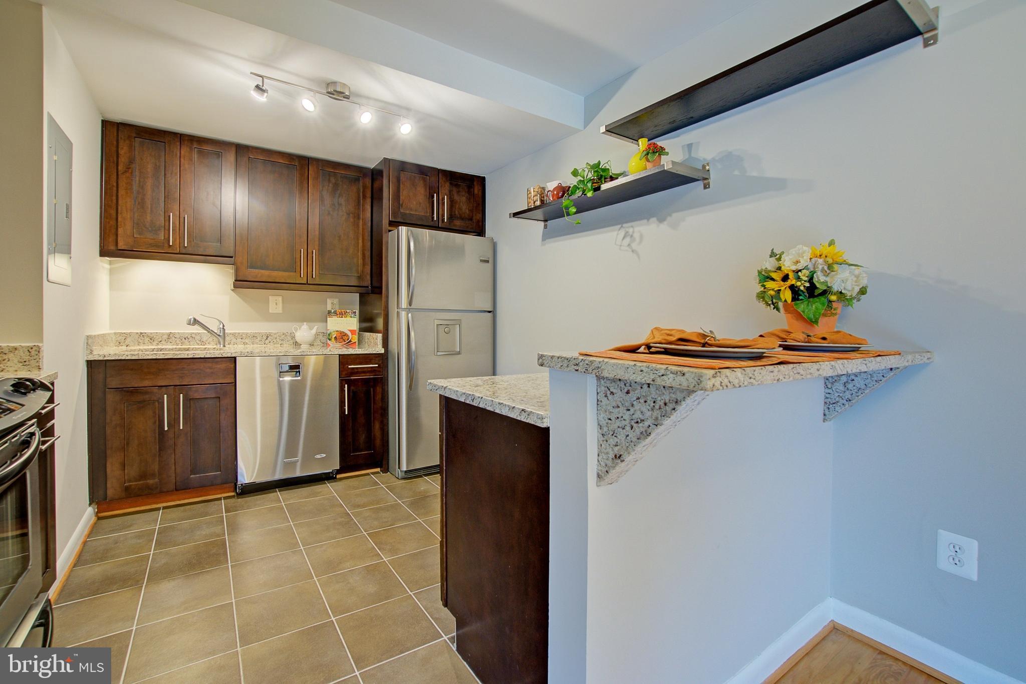 8706 Manchester Road, Unit 5 Silver Spring, MD 20901 - Photo 6 of 25 a kitchen with stainless steel appliances a stove a refrigerator a sink a stove with wooden floor
