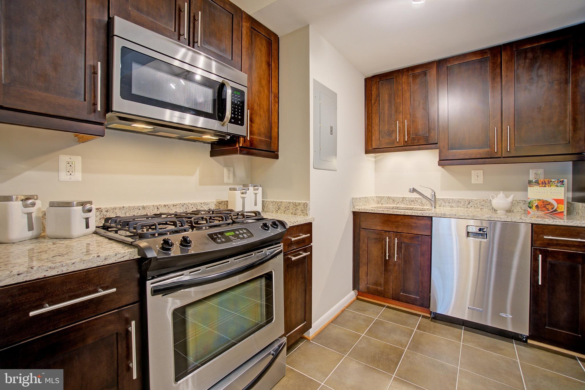 8706 Manchester Road, Unit 5 Silver Spring, MD 20901 - Photo 7 of 25 a kitchen with granite countertop cabinets stainless steel appliances and wooden cabinets