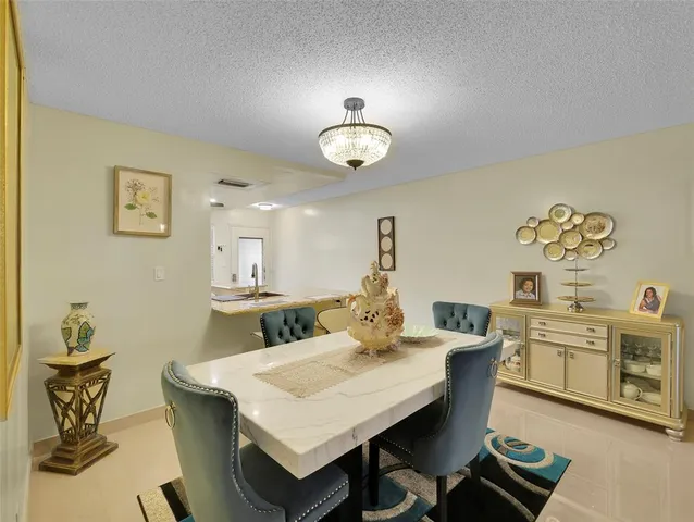 a view of a dining room with furniture a chandelier and wooden floor