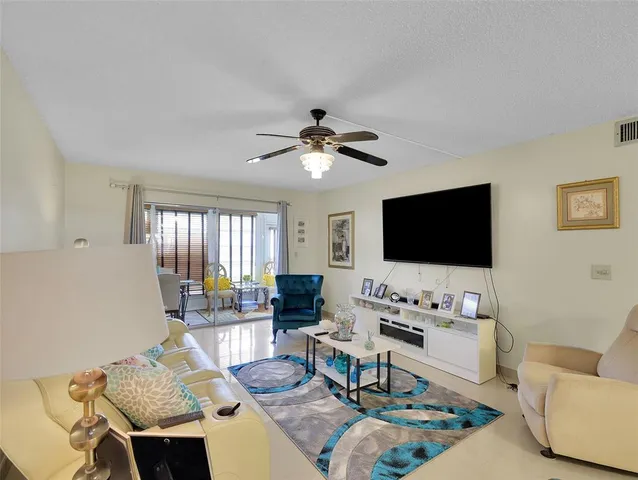 a living room with furniture a flat screen tv and a large window