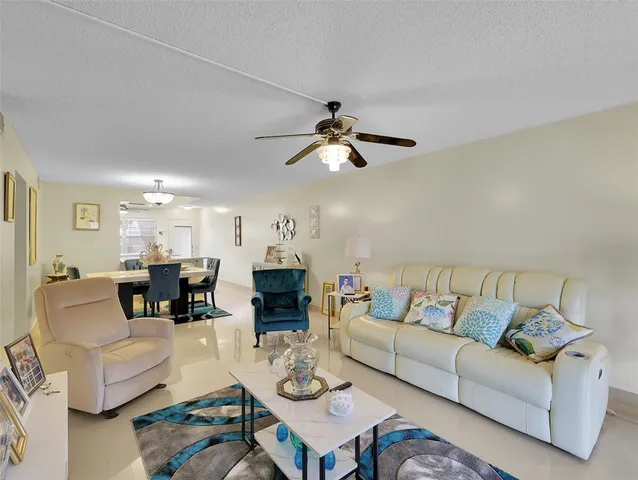 a living room with furniture ceiling fan and a rug