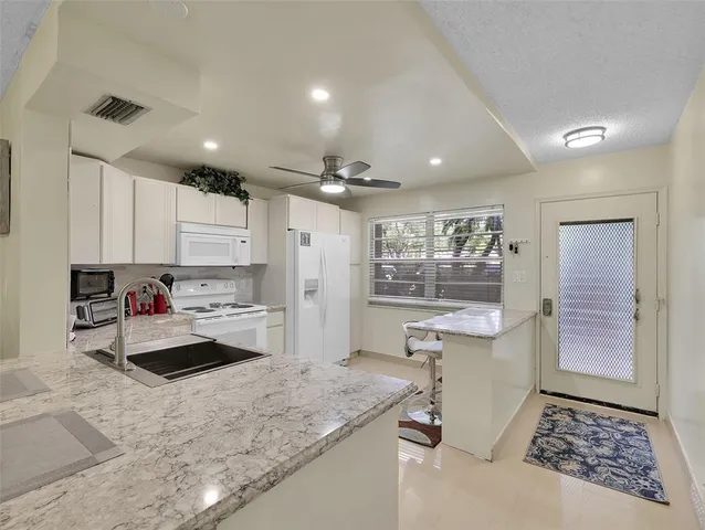 a kitchen with sink refrigerator and cabinets