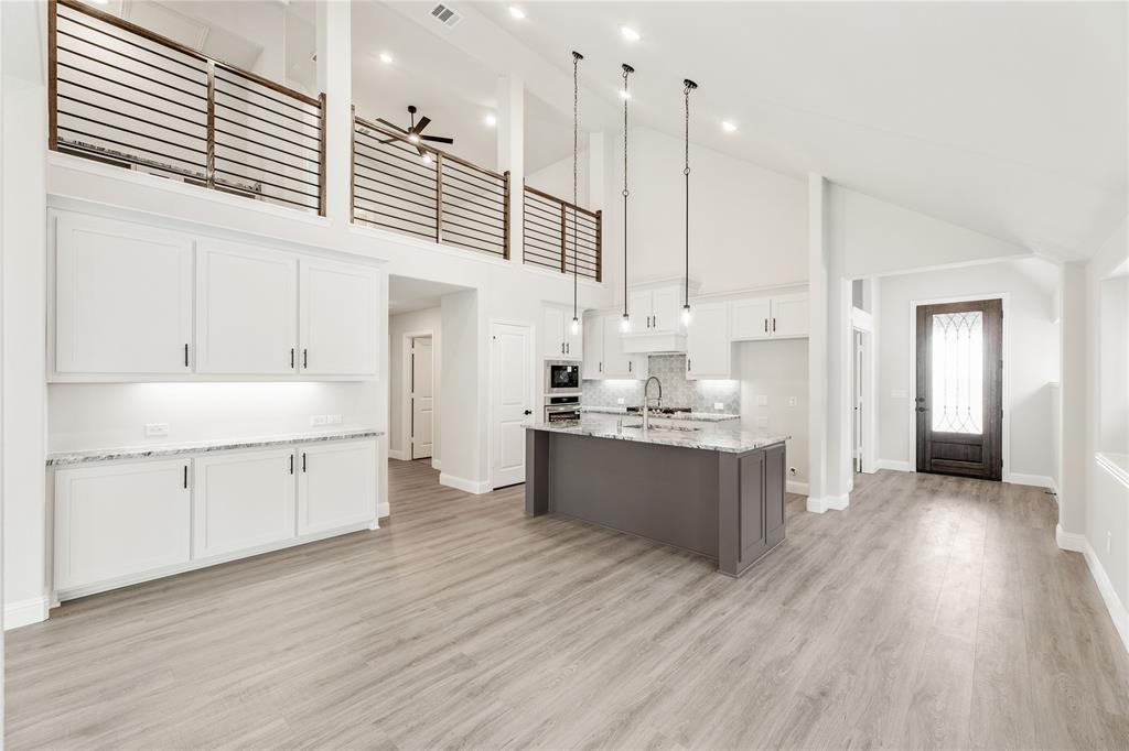 14505 Lovelace Street Pilot Point, TX 76258 - Photo 20 of 37 a large white kitchen with kitchen island white cabinets and wooden floors