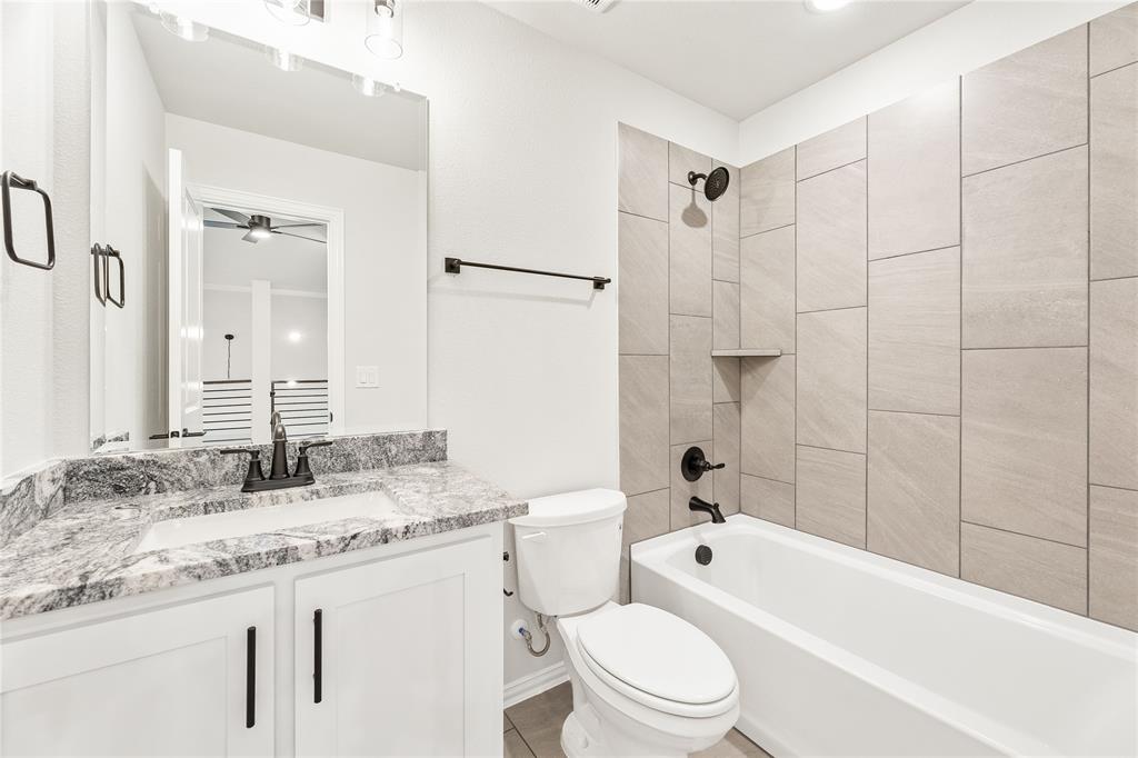 14505 Lovelace Street Pilot Point, TX 76258 - Photo 33 of 37 a bathroom with a granite countertop sink a toilet and shower