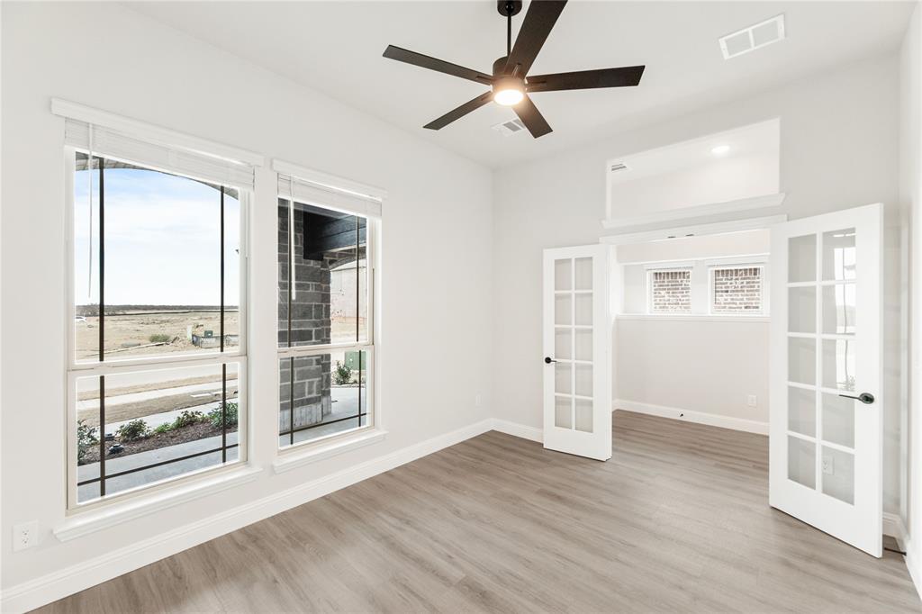 14505 Lovelace Street Pilot Point, TX 76258 - Photo 6 of 37 an empty room with wooden floor and windows