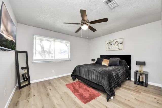 a bedroom with a bed and wooden floor