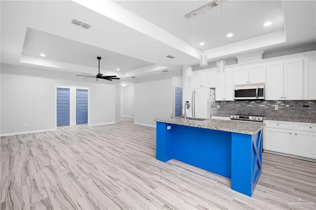 a kitchen with stainless steel appliances granite countertop a stove and a wooden cabinets