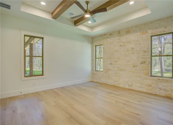 an empty room with windows and fan