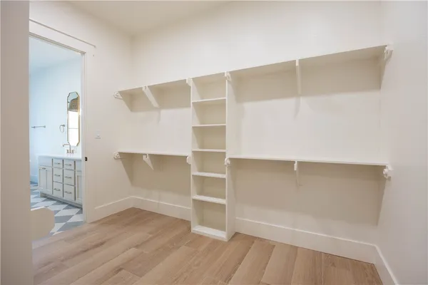 a view of an empty room with wooden floor and closet