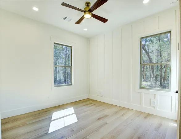 a view of an empty room with a window and wooden floor