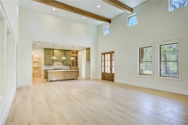 a view of a livingroom with wooden floor kitchen view and a fireplace