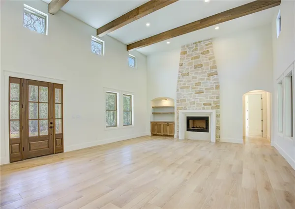 a view of an empty room with a fireplace and a window