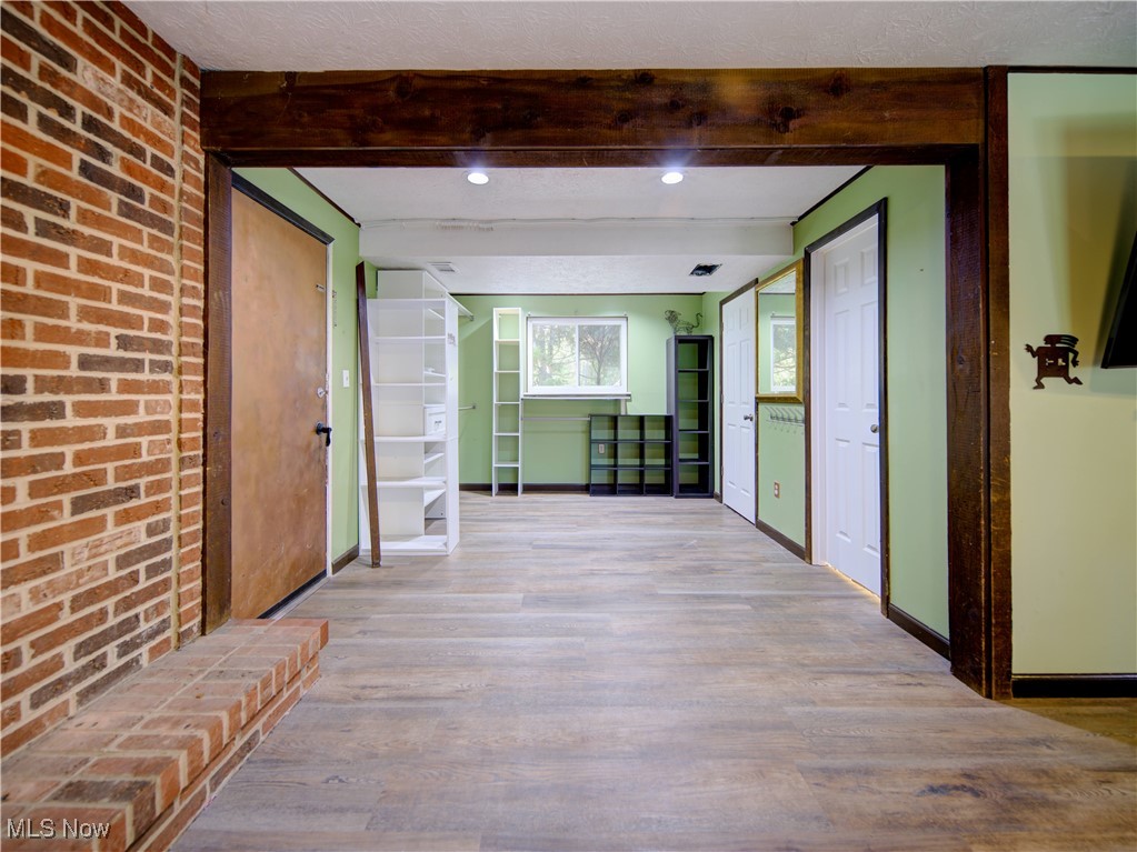 8075 Mulberry Road Chesterland, OH 44026 - Photo 19 of 38 Hall featuring wood finished floors, brick wall, and beam ceiling