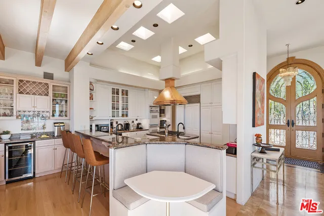 a kitchen with kitchen island granite countertop a sink a counter top space and living room view