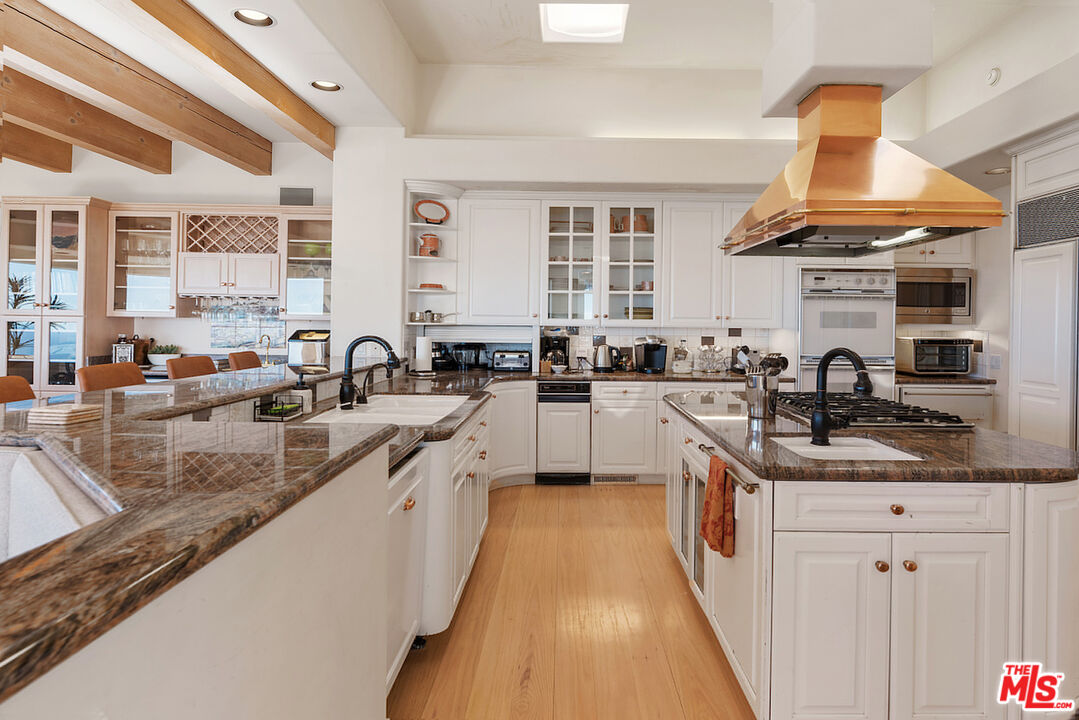 7350 Brodiaea Way La Jolla, CA 92037 - Photo 14 of 60 a kitchen with stainless steel appliances granite countertop a sink a stove and a wooden floors