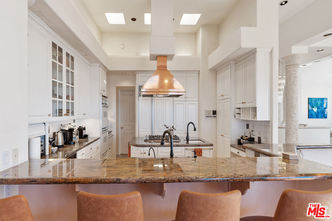 7350 Brodiaea Way La Jolla, CA 92037 - Photo 15 of 60 a kitchen with kitchen island granite countertop a sink a counter top space and living room view