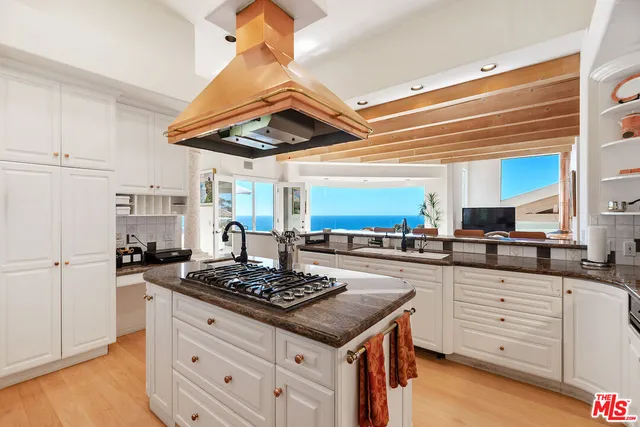 a kitchen with stainless steel appliances granite countertop a stove a sink dishwasher and a refrigerator with wooden floor