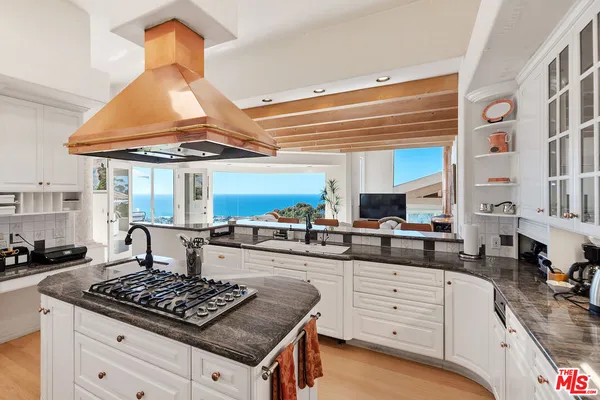 a living room with furniture a flat screen tv and kitchen view
