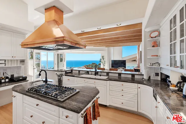 a living room with furniture a flat screen tv and kitchen view