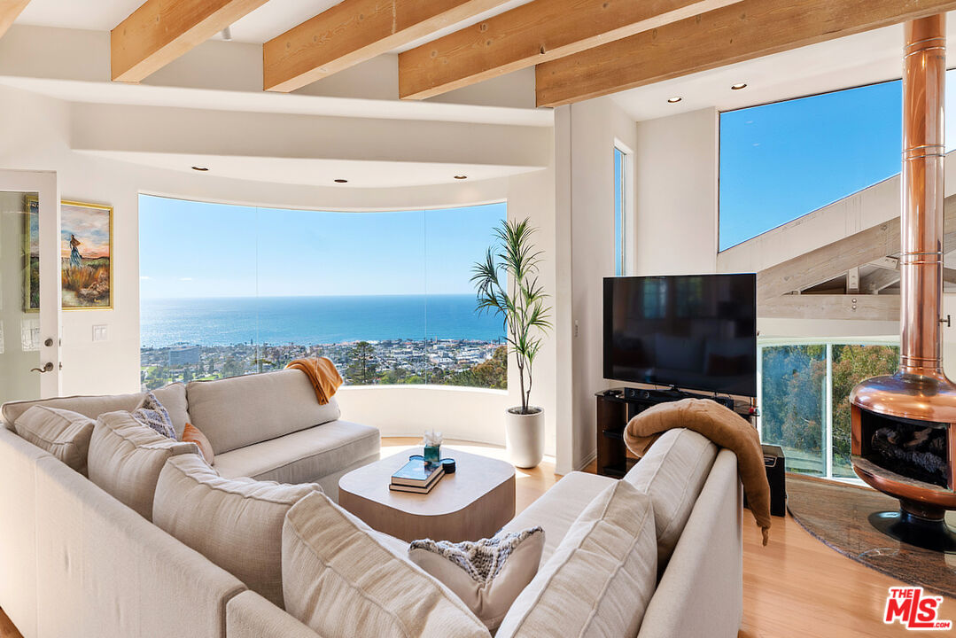 7350 Brodiaea Way La Jolla, CA 92037 - Photo 22 of 60 a living room with furniture a flat screen tv and kitchen view