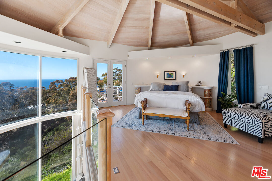 7350 Brodiaea Way La Jolla, CA 92037 - Photo 29 of 60 a bedroom with a bed and wooden floor